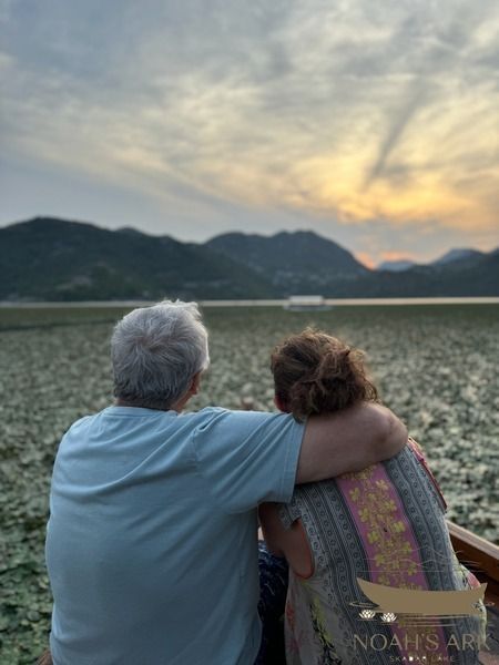 Traditional wooden boat on Skadar Lake near Virpazar, Montenegro, with green shores and mountain views